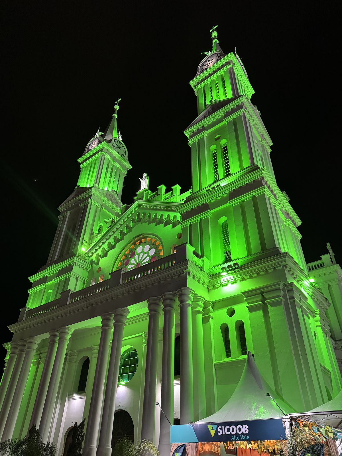 Fachada da Catedral São João Batista iluminada de verde durante a festa