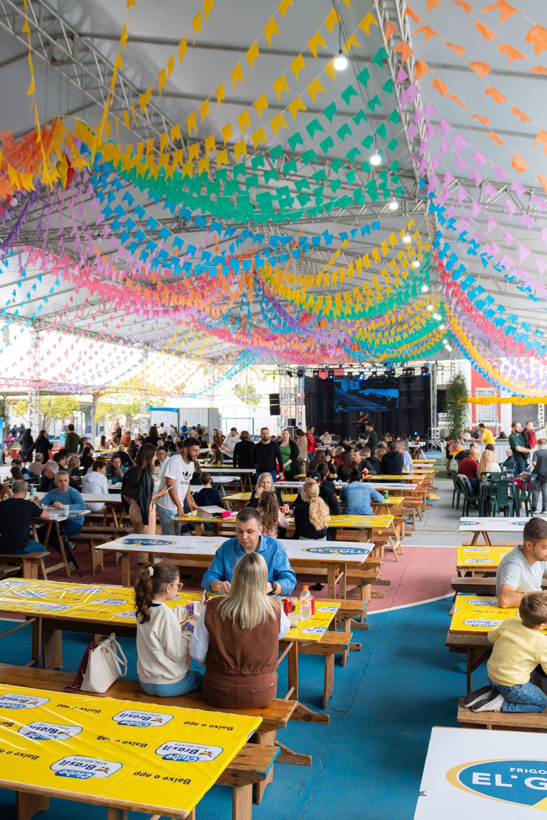 Salão da festa durante o dia, decorado com bandeirinhas coloridas